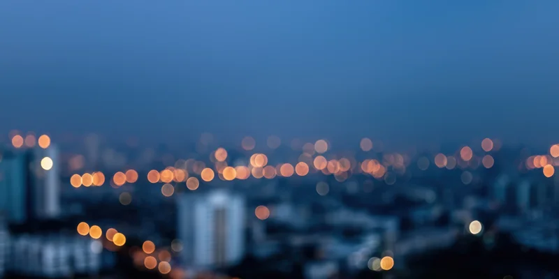 Blurred cityscape at night with bokeh lights and hazy skyline view