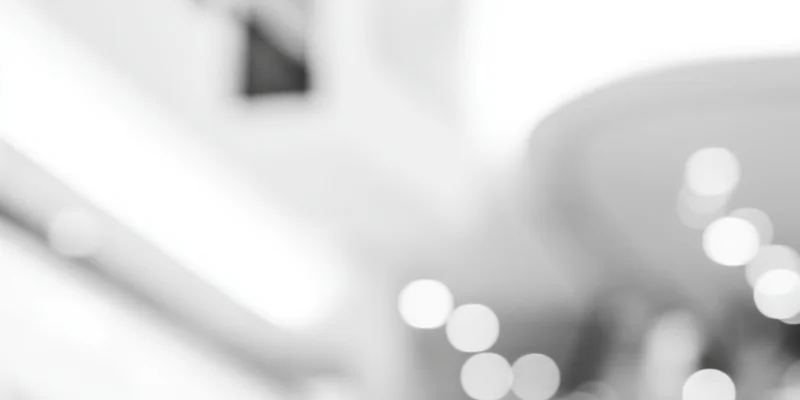 Blurred interior scene with soft glowing lights and high-key grayscale tones