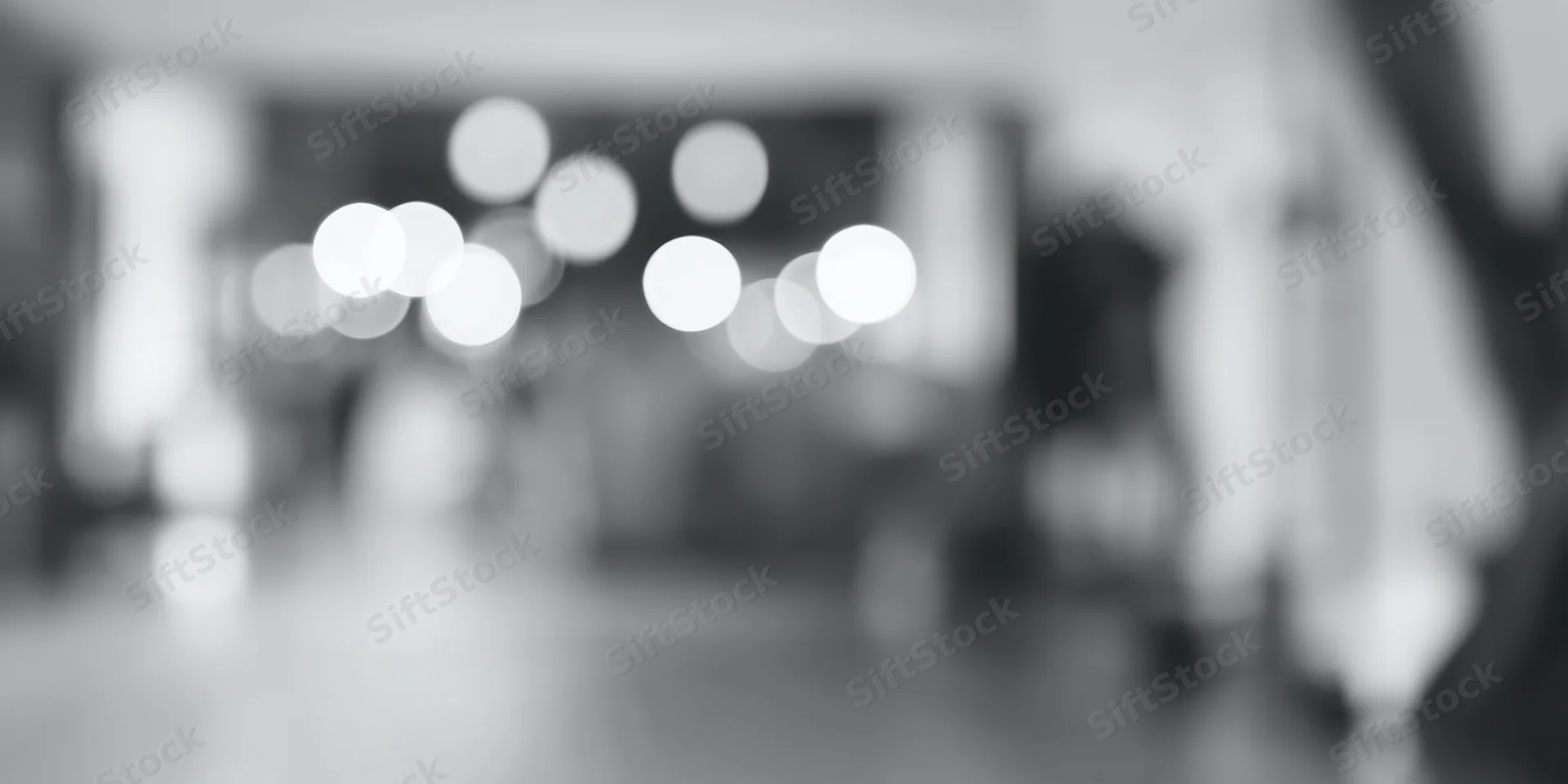 Blurred circular lights in a high-key grayscale interior space