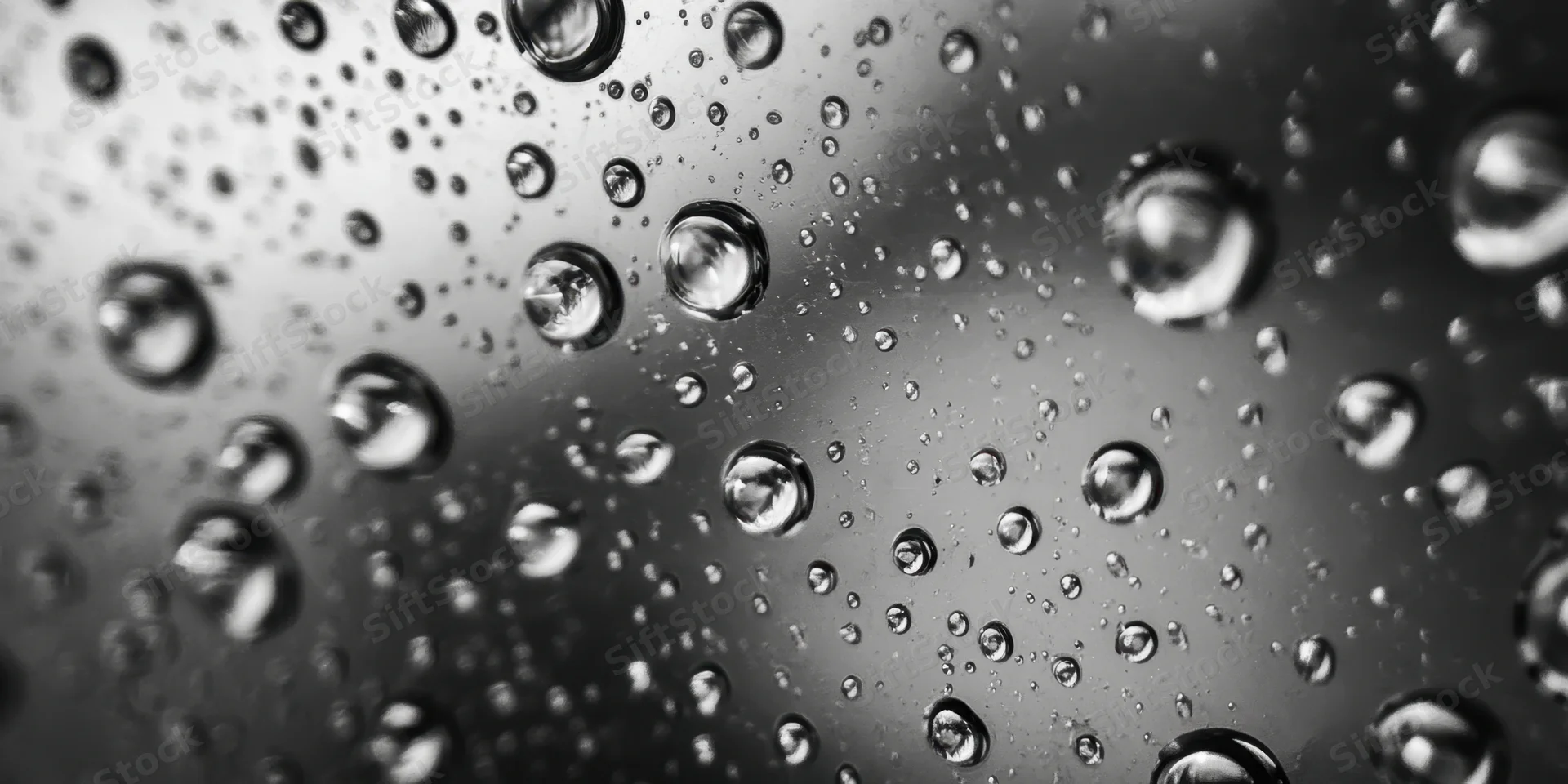 Water droplets clinging to a glass surface in macro closeup