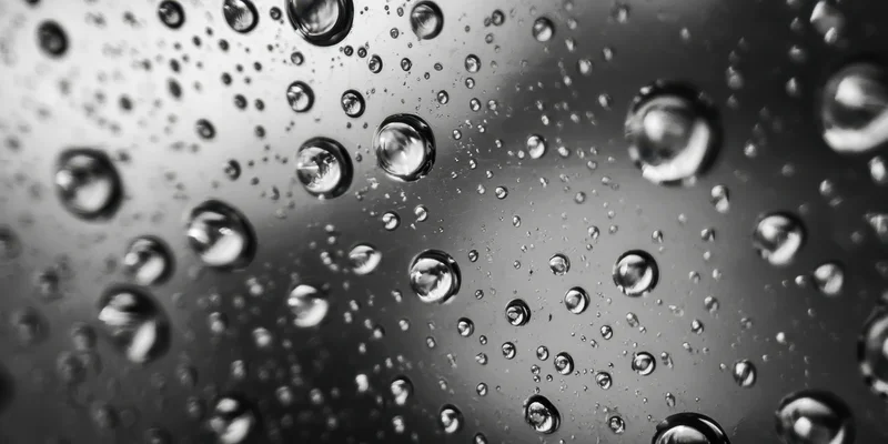 Water droplets clinging to a glass surface in macro closeup