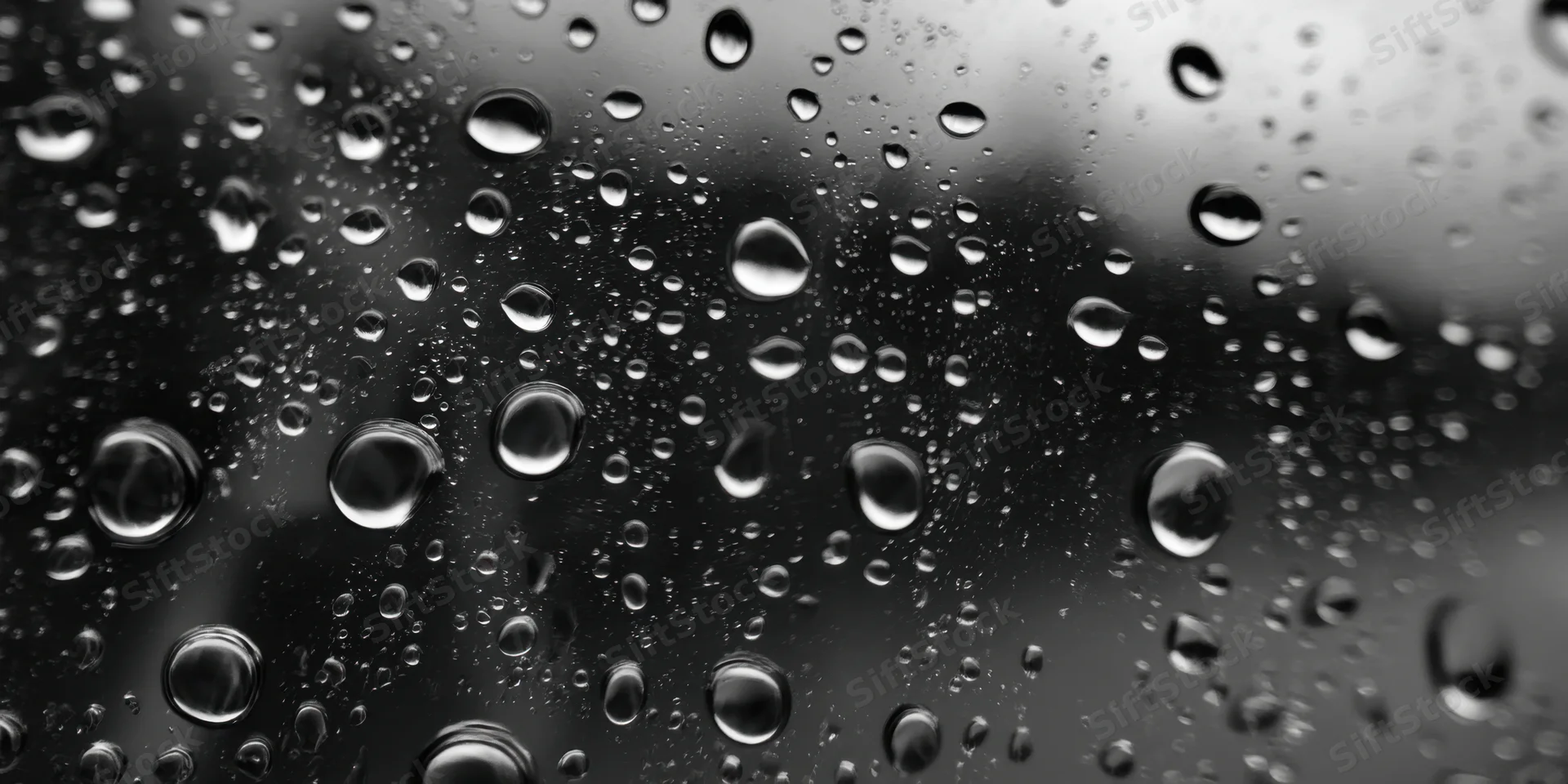 Water droplets clinging to a glass surface in macro closeup