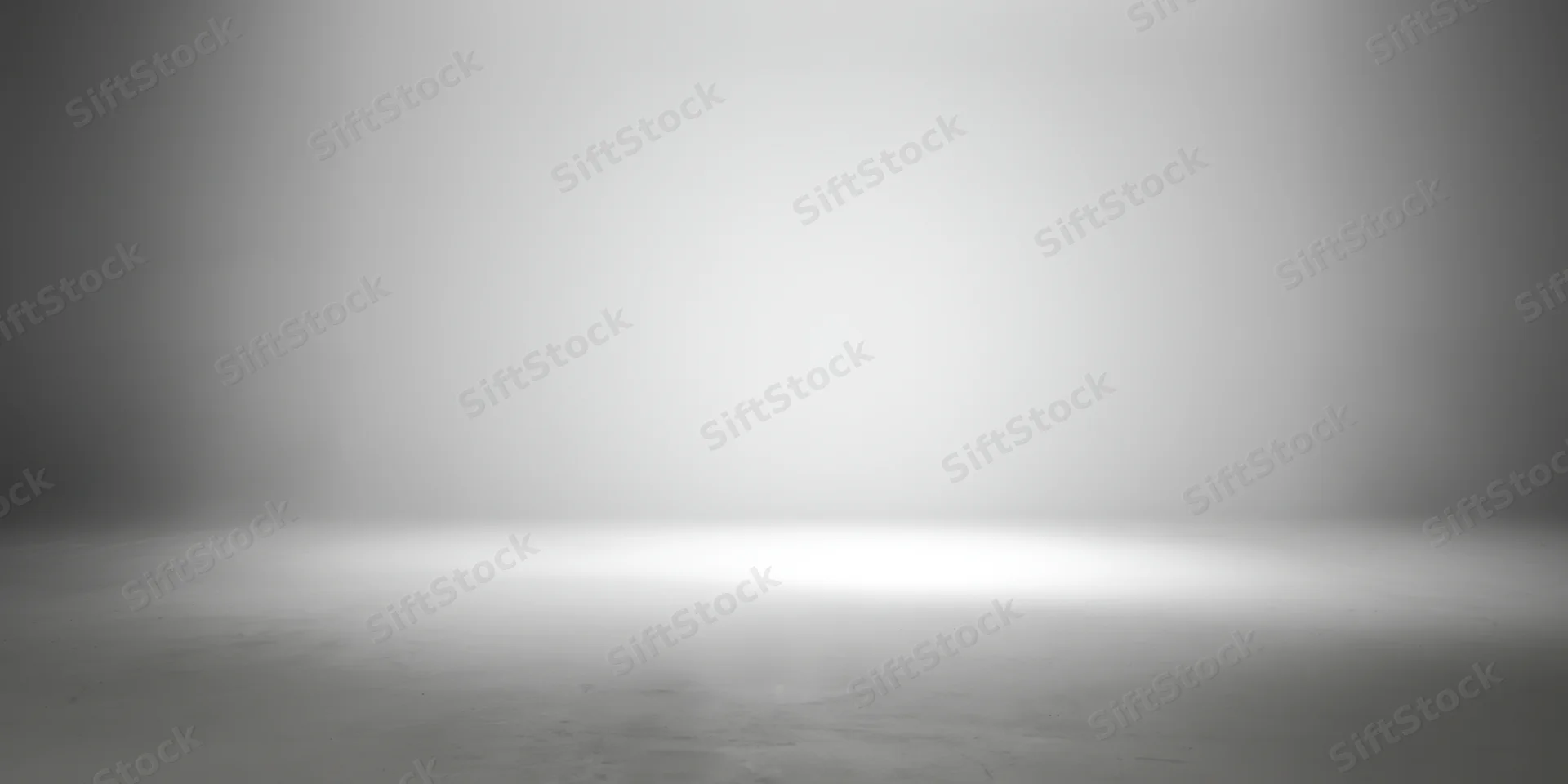 Empty studio space with smooth grey gradient backdrop and concrete floor