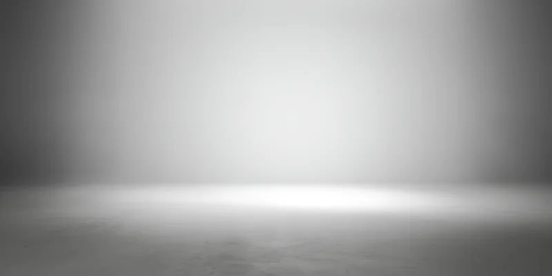 Empty studio space with smooth grey gradient backdrop and concrete floor