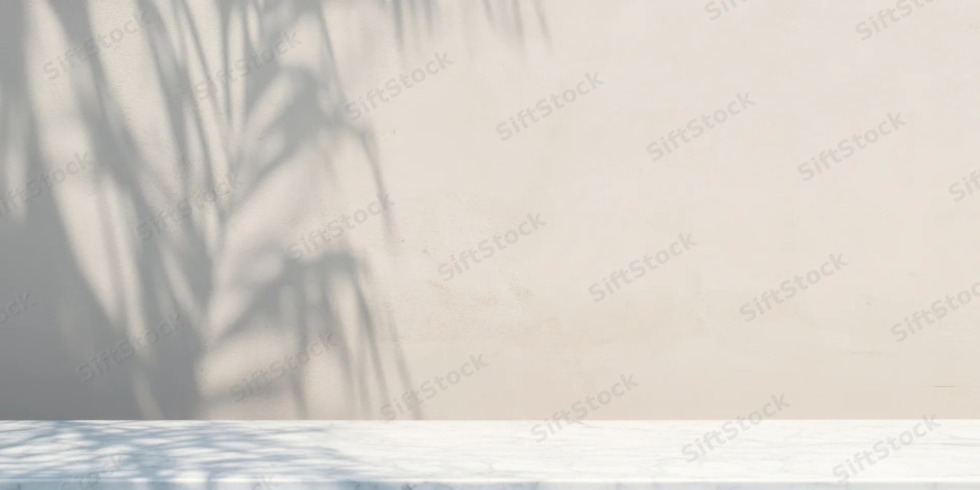 Palm shadow on textured wall above white wooden table in minimal interior