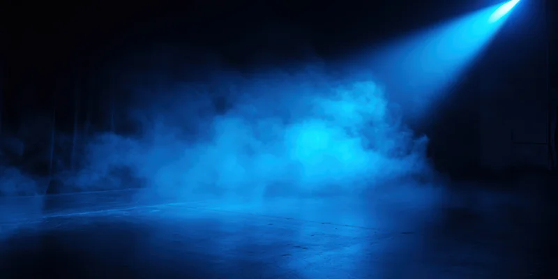 Blue spotlight illuminating drifting fog on an empty stage floor