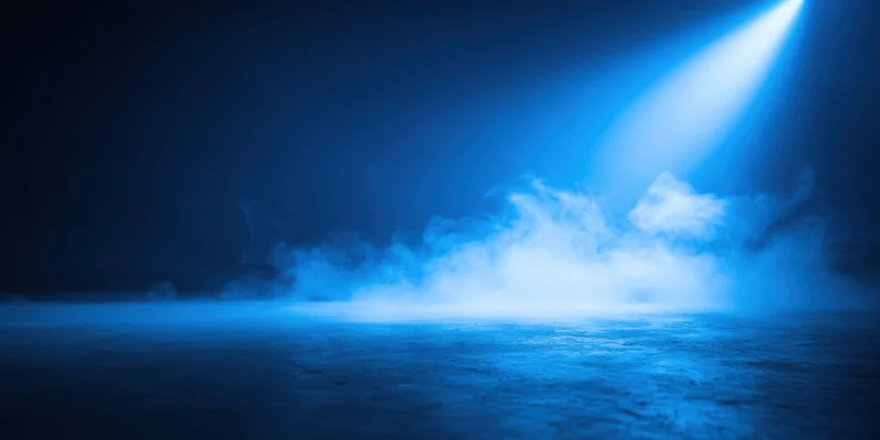 Spotlight beam cutting through thick fog on a dark stage