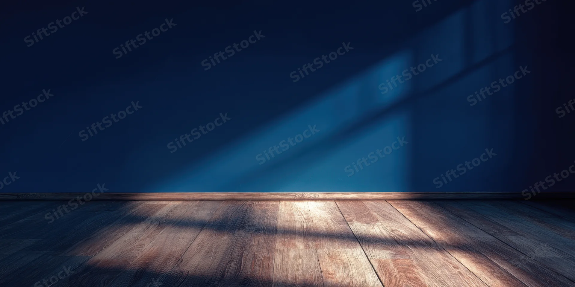 Empty room with deep blue wall and wooden floor lit by diagonal sunlight casting shadows