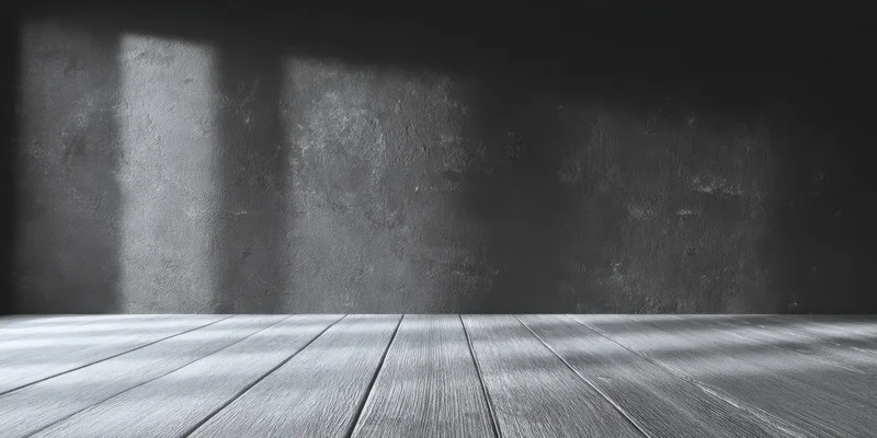 Dark textured wall with wooden floor in moody grayscale interior