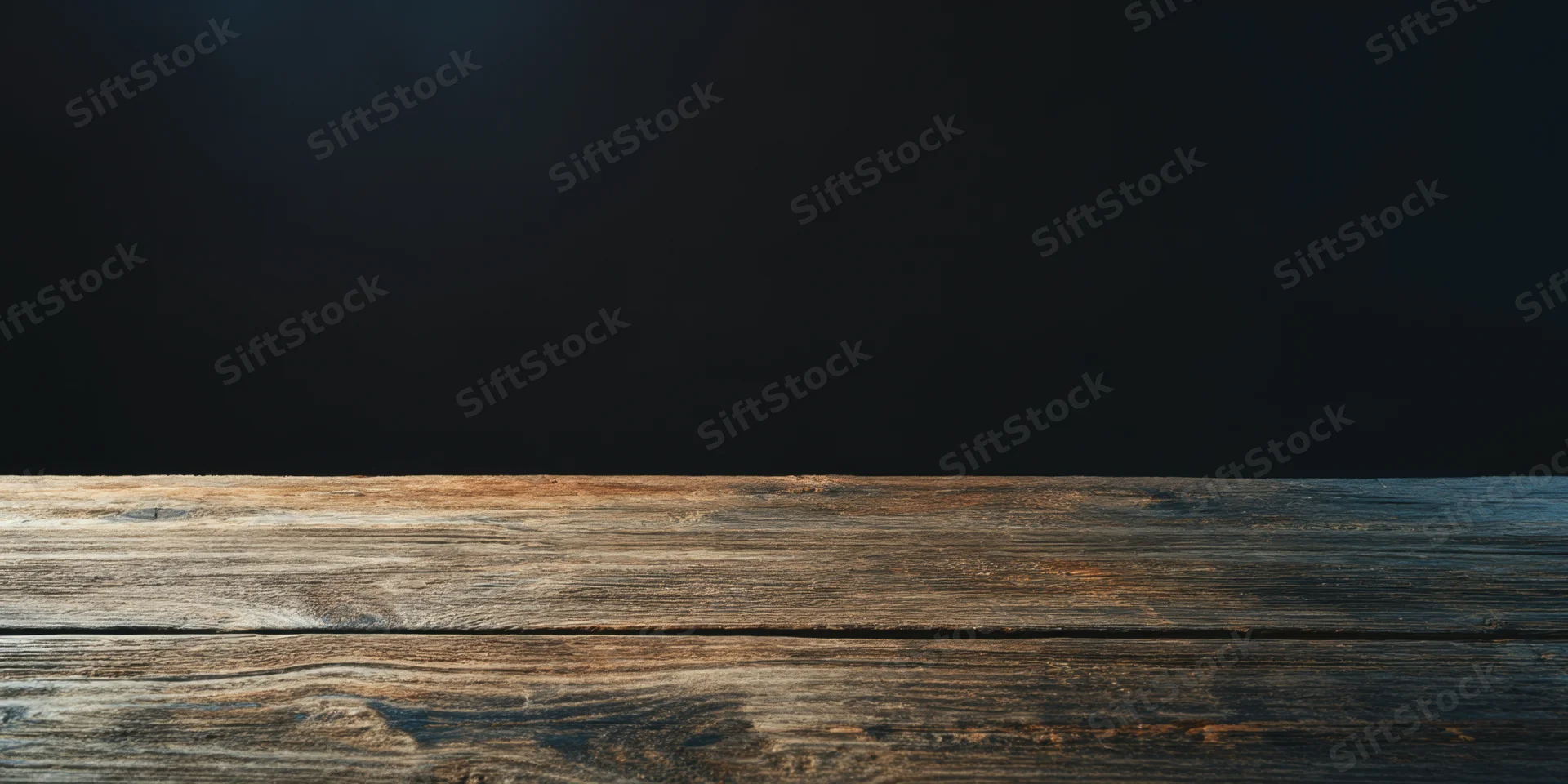 Weathered wooden table surface against dark studio wall with copyspace