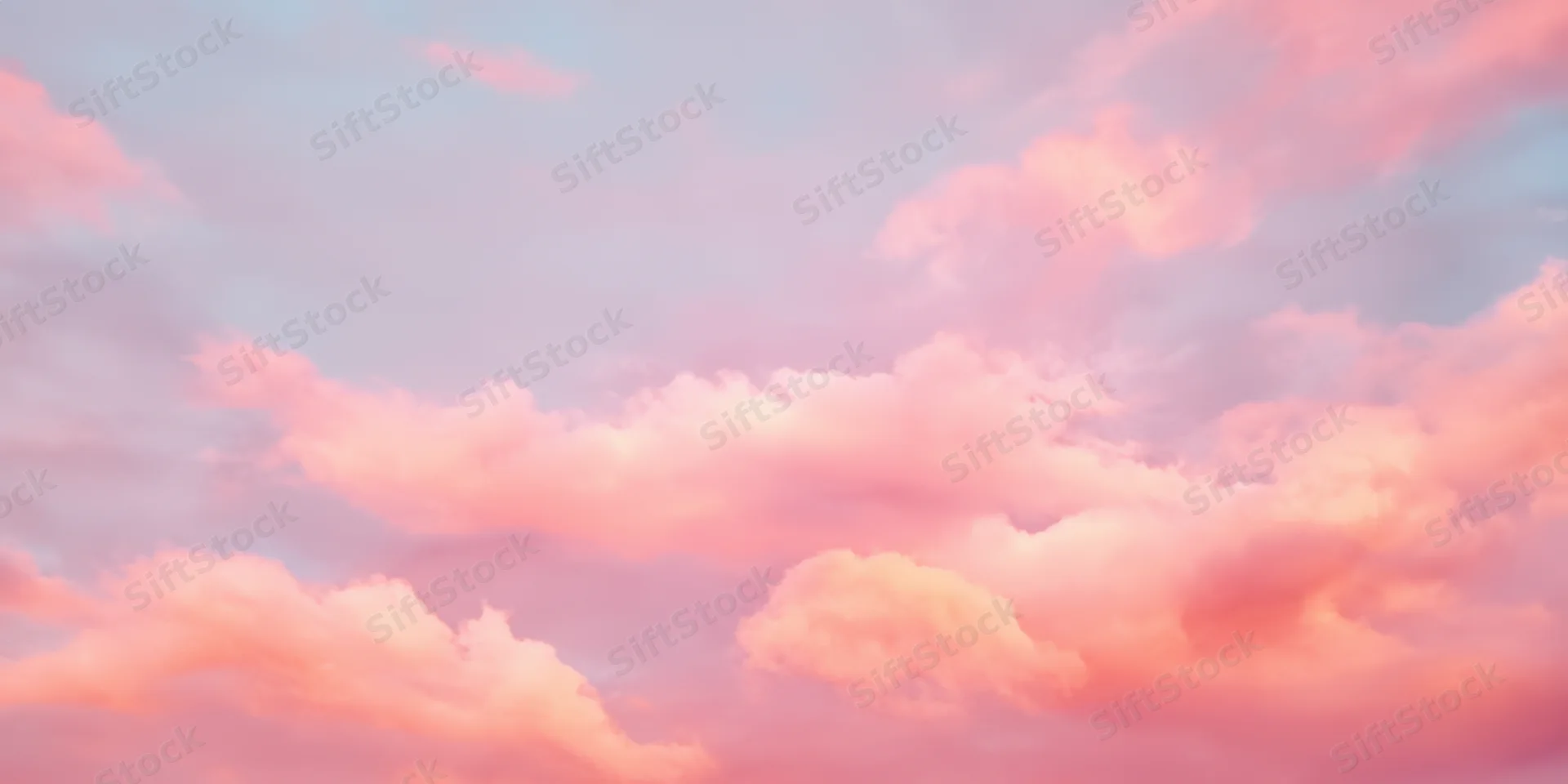 Pastel sky with soft fluffy clouds in pink and peach hues during daytime