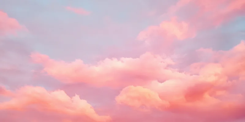 Pastel sky with soft fluffy clouds in pink and peach hues during daytime