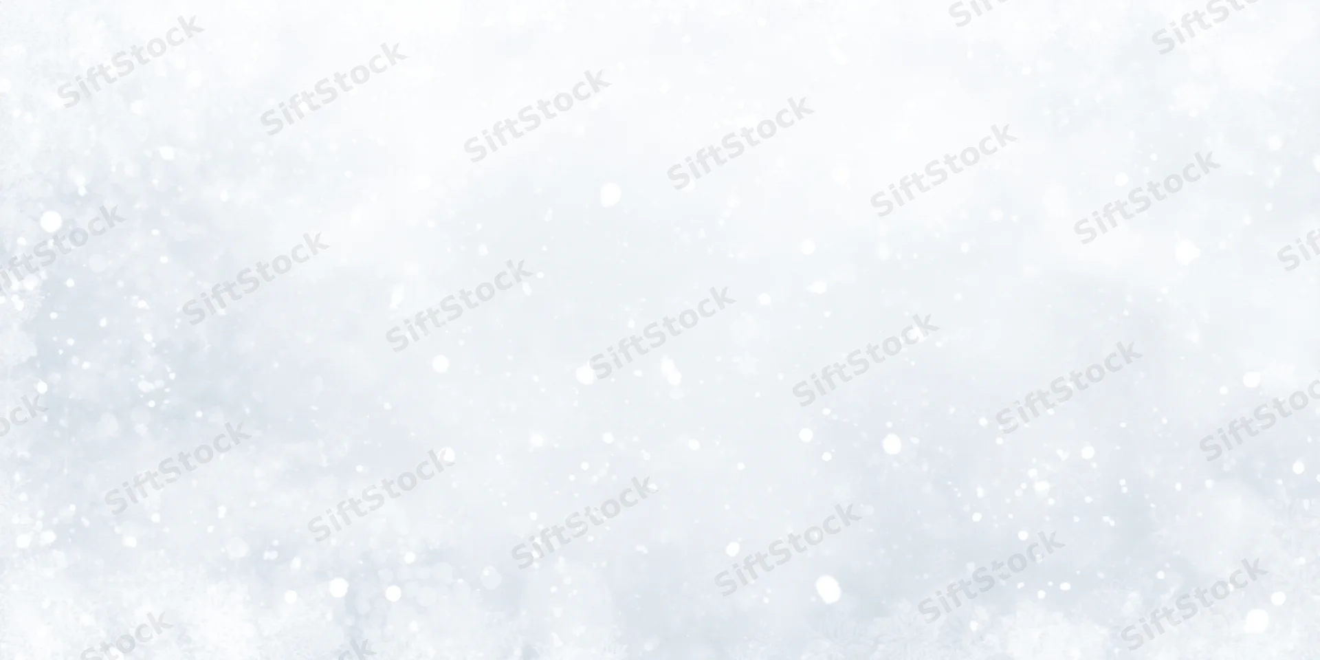 Soft snowfall drifting across a white winter sky with gentle bokeh and copyspace