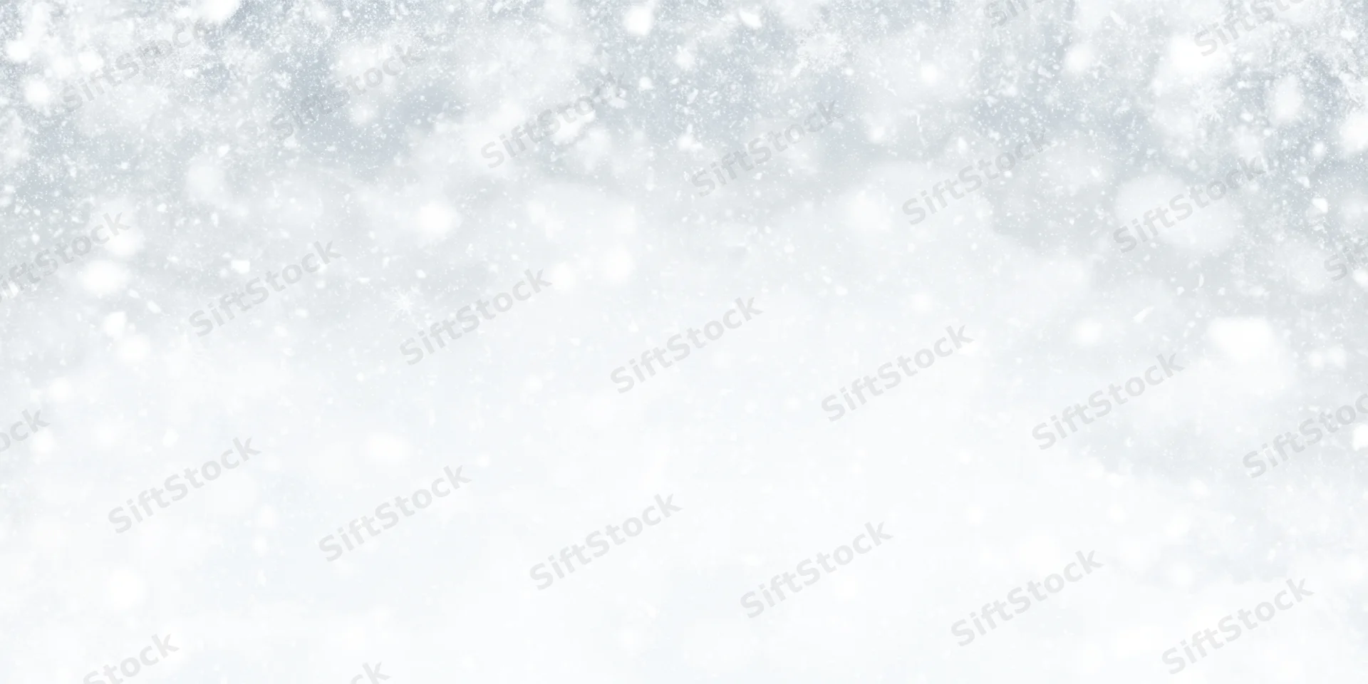 Soft snowfall drifting across a white winter sky