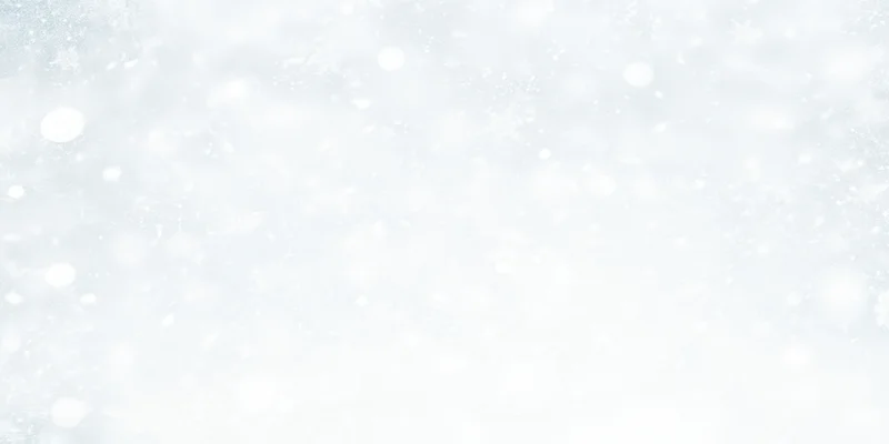 Soft snowfall drifting across a white winter background with blurred bokeh and copyspace