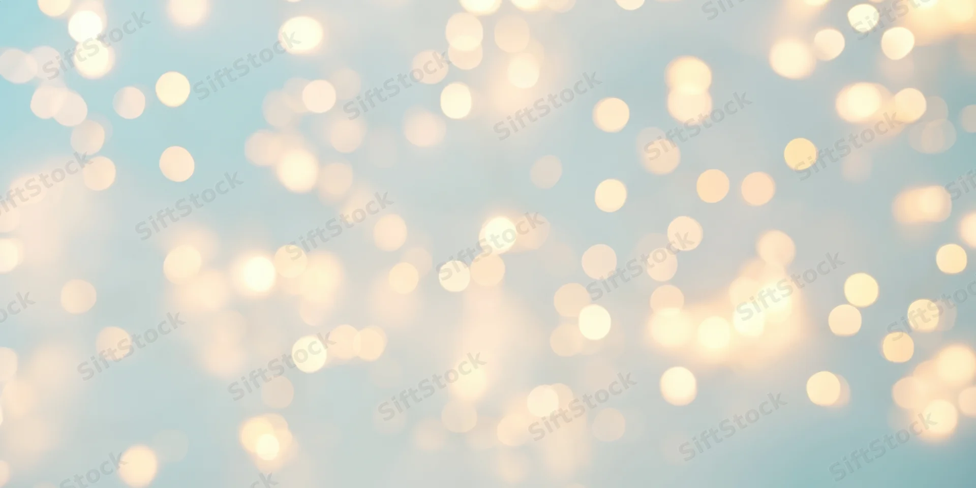Warm fairy lights in soft bokeh against a pale blue background
