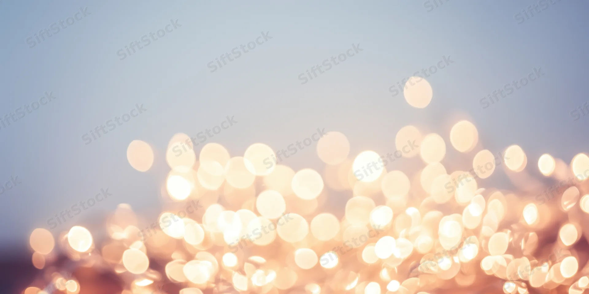 Warm fairy lights creating a soft bokeh effect against a pale background