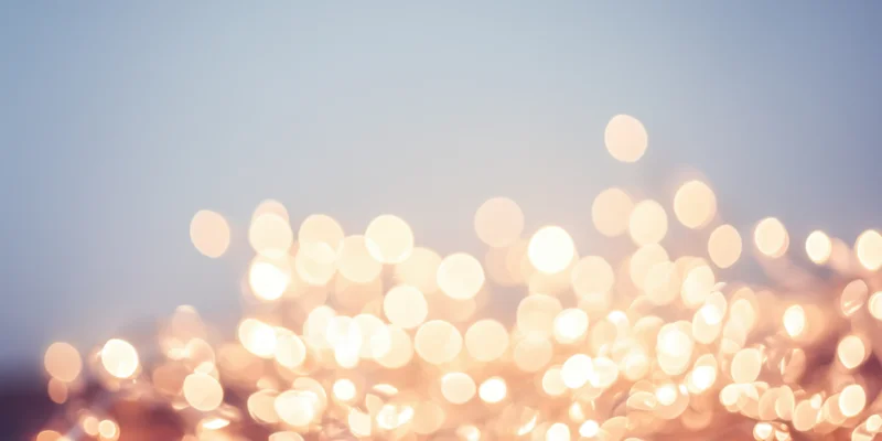 Warm fairy lights creating a soft bokeh effect against a pale background