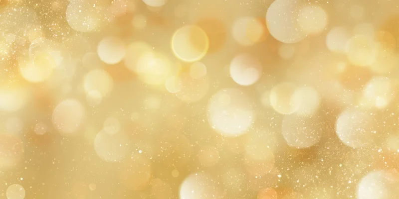 Soft golden background with round bokeh lights and sparkling particles