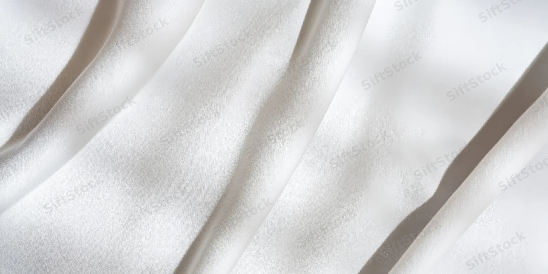 White fabric with gentle folds and soft shadows filling the frame