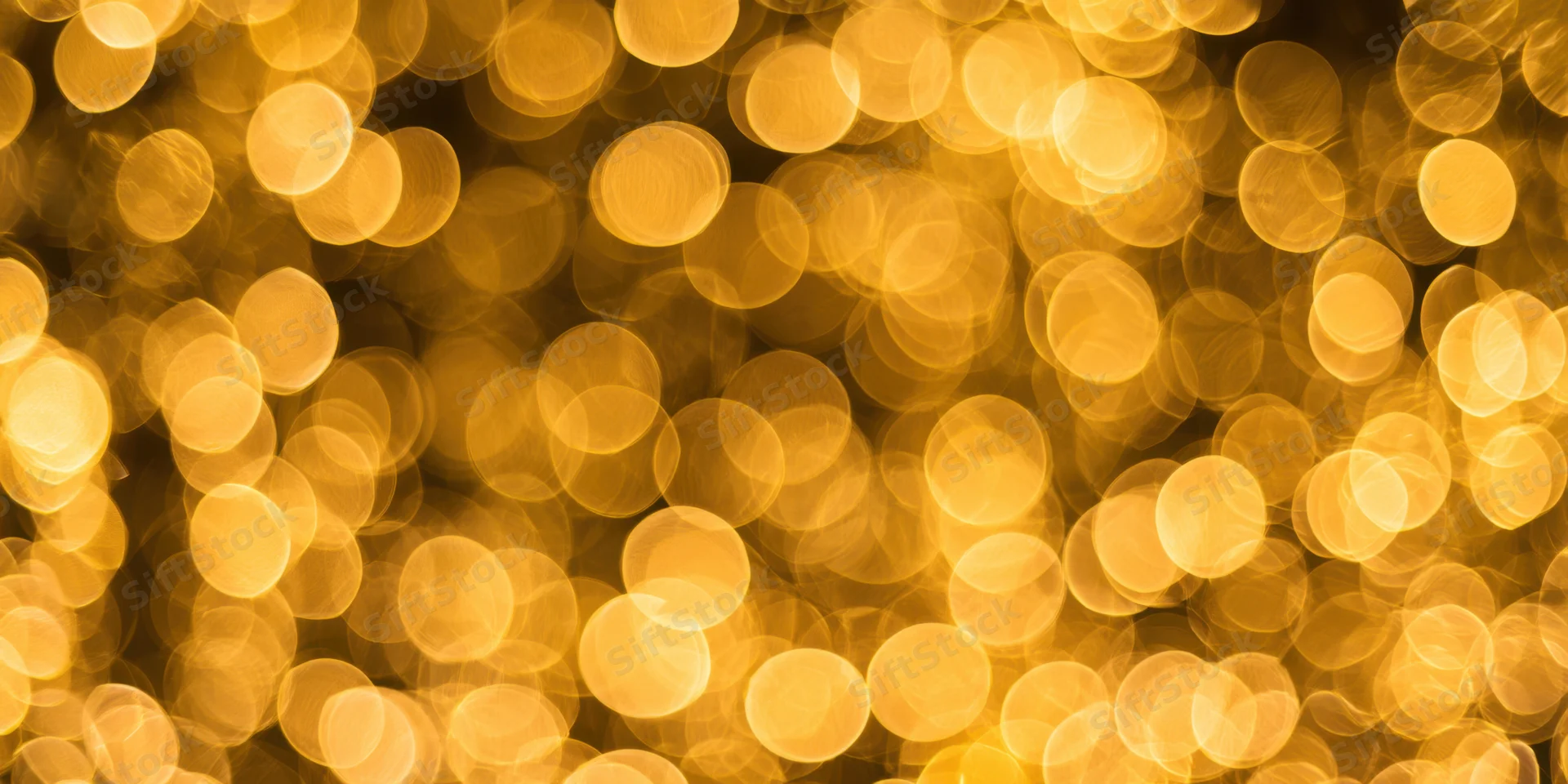 Golden bokeh lights arranged in a warm abstract background with soft glow and circular blur