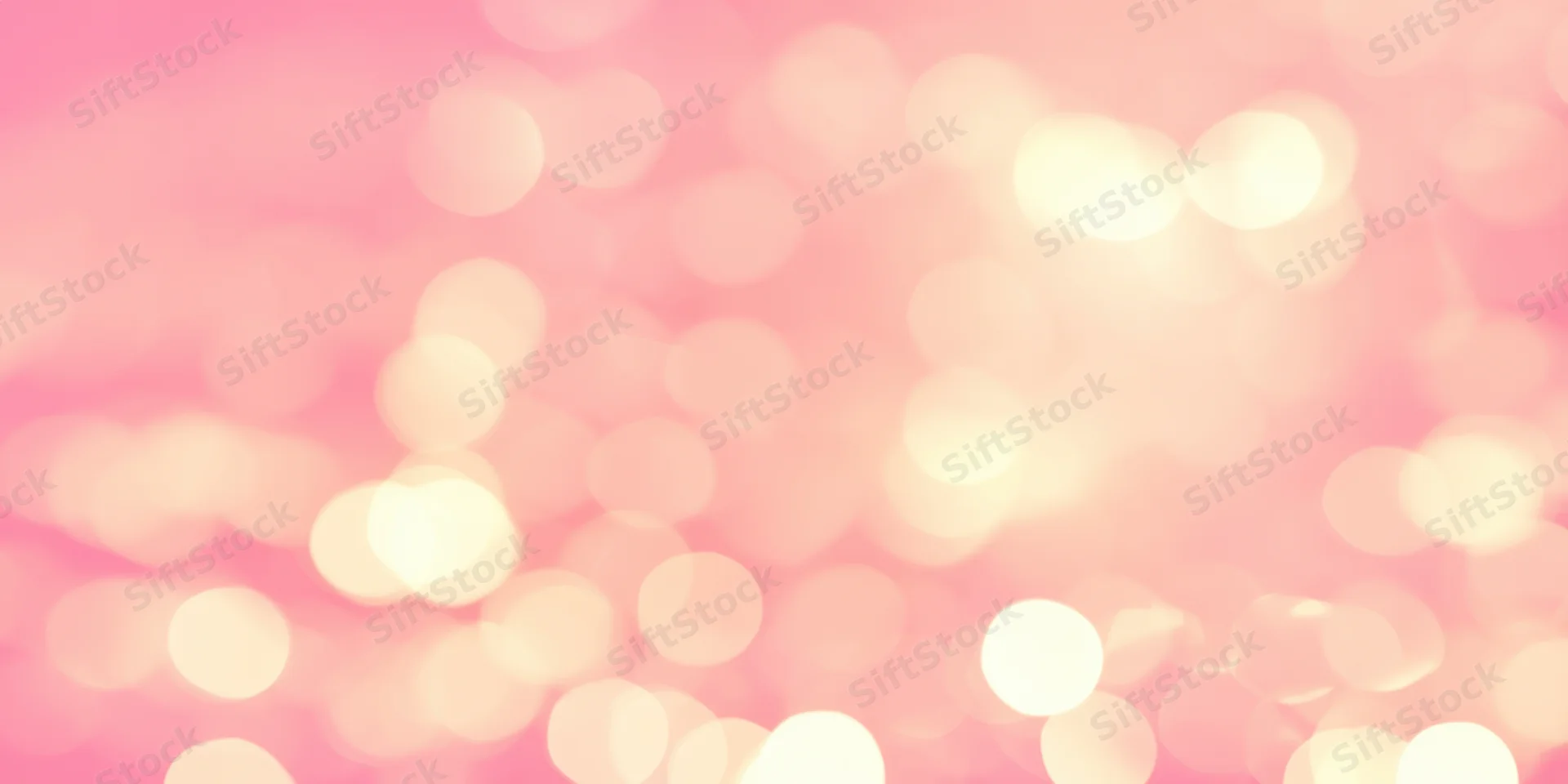Soft pink bokeh background with warm glowing orbs of light scattered across the frame