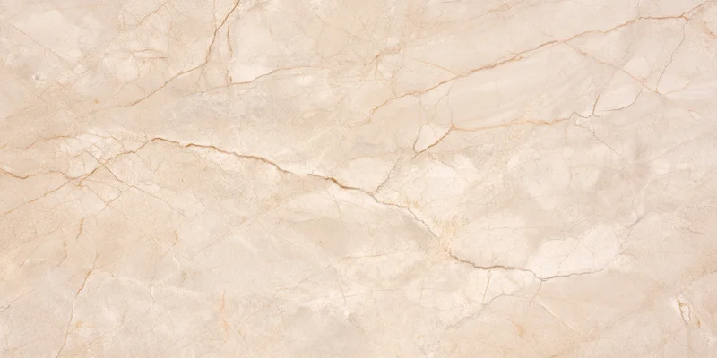 Close-up of a beige stone surface with delicate veining and natural cracks