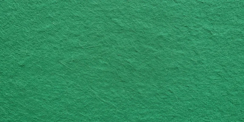 Close-up of a green felt surface showing fibrous texture and uniform color