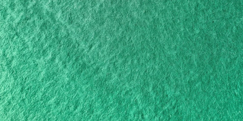 Close-up of a green felt-like textured surface filling the frame