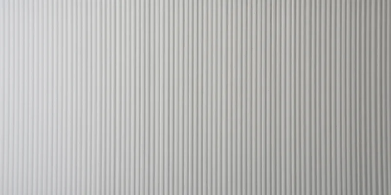 Close-up of a pale grey ribbed surface with vertical grooves forming a repeating linear pattern