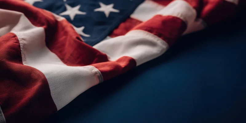 Closeup of american flag draped over dark blue surface