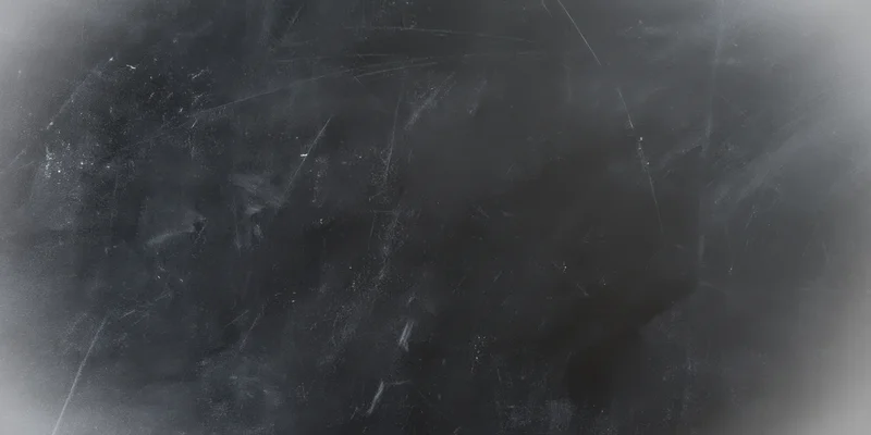 Dark textured chalkboard surface with faint scratches and smudges