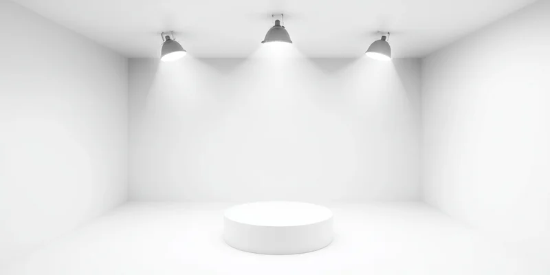 White circular pedestal under three overhead spotlights in a minimalist studio space