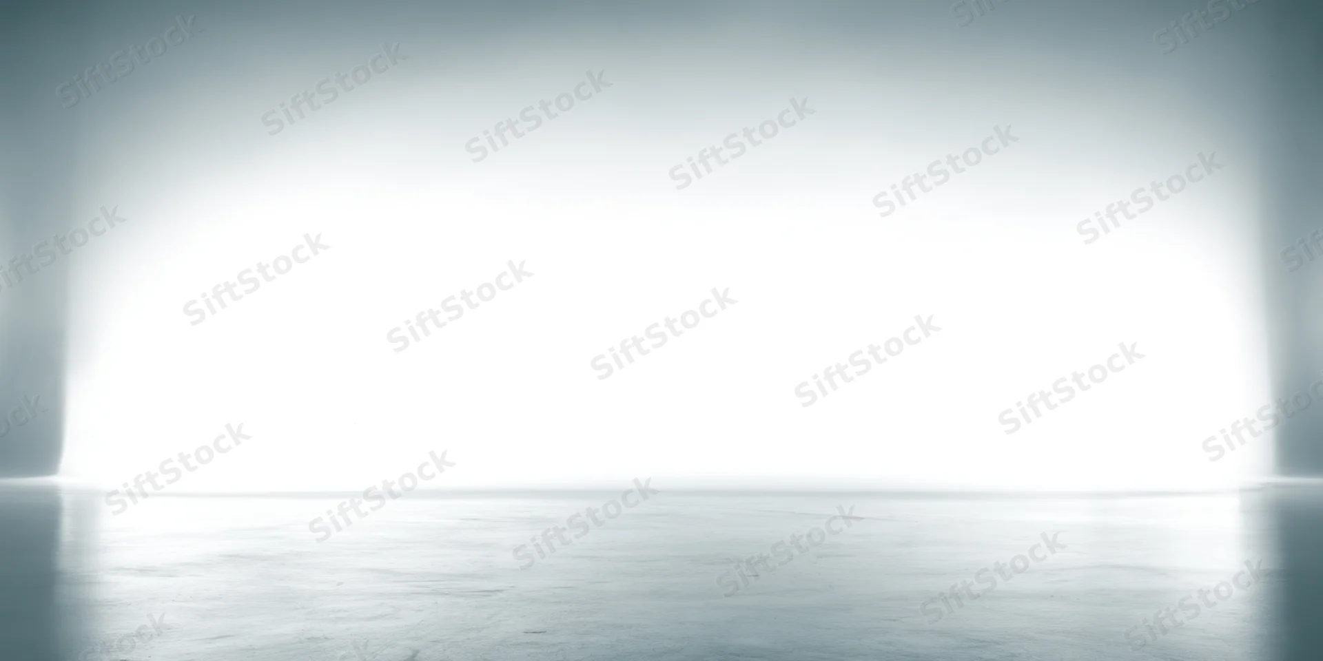 Soft white to light gray gradient backdrop in a studio interior with reflective floor and copyspace