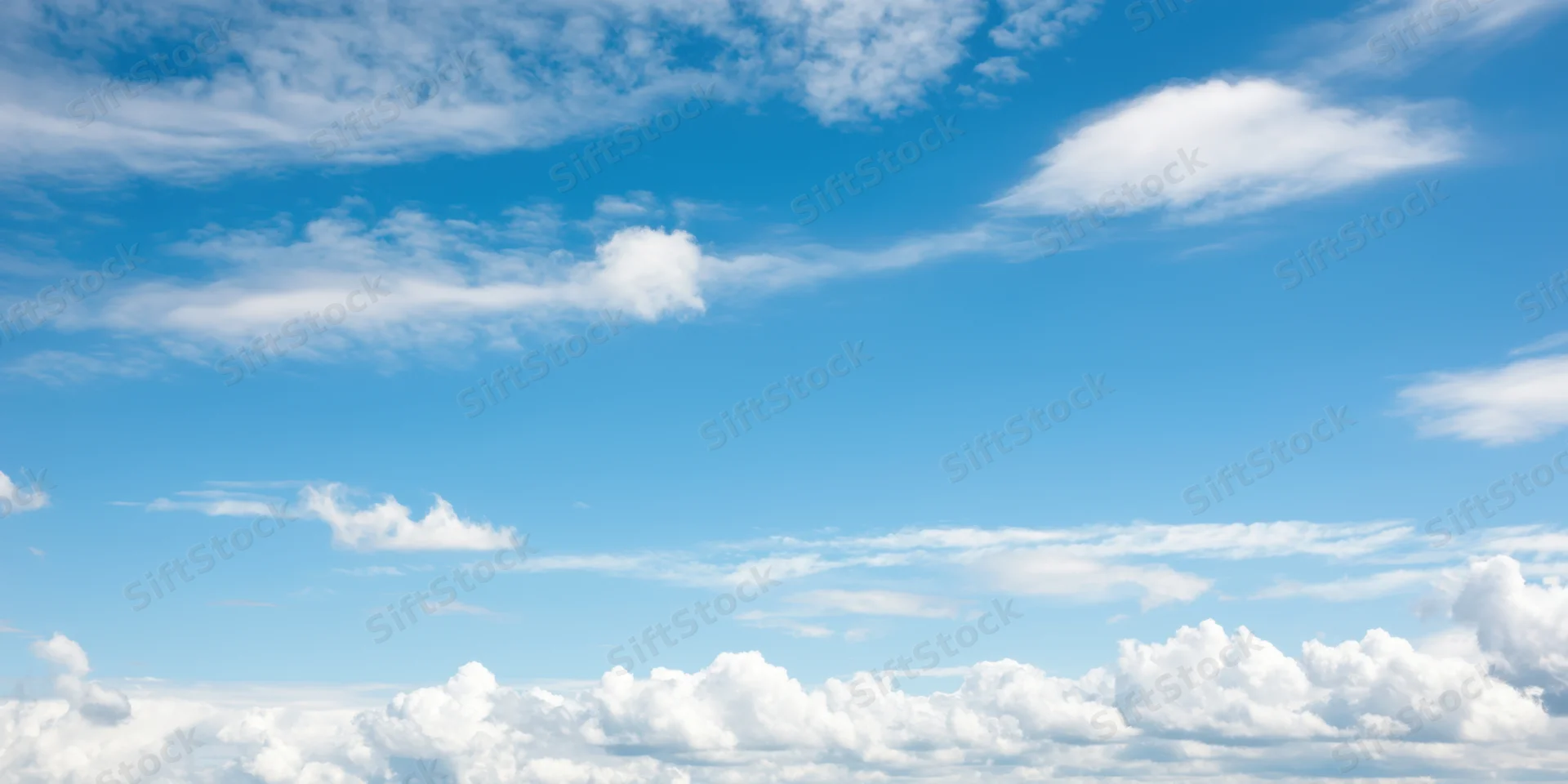 Fluffy white clouds scattered across a clear blue sky during daytime
