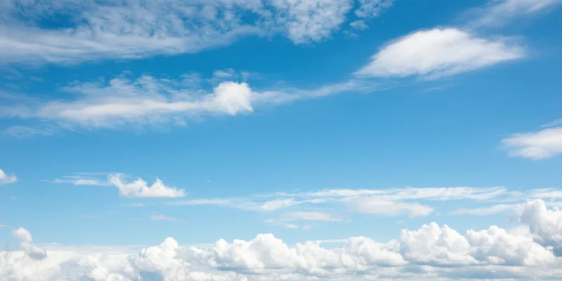 Fluffy white clouds scattered across a clear blue sky during daytime