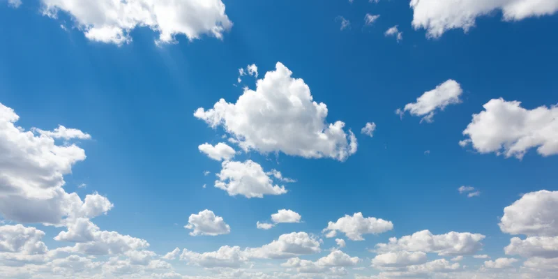 Blue sky with fluffy white clouds scattered across the horizon