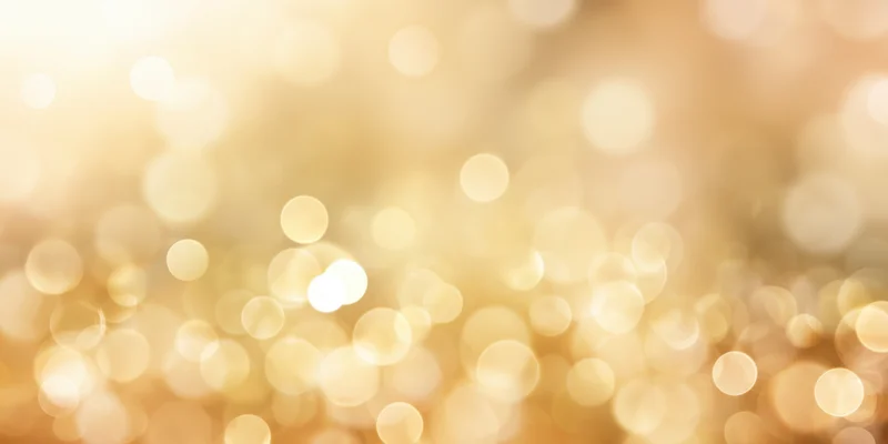 Soft golden bokeh background with scattered light orbs and warm glow