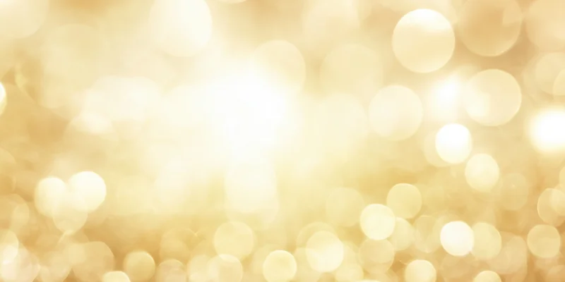 Soft golden bokeh background with scattered light orbs and warm glow