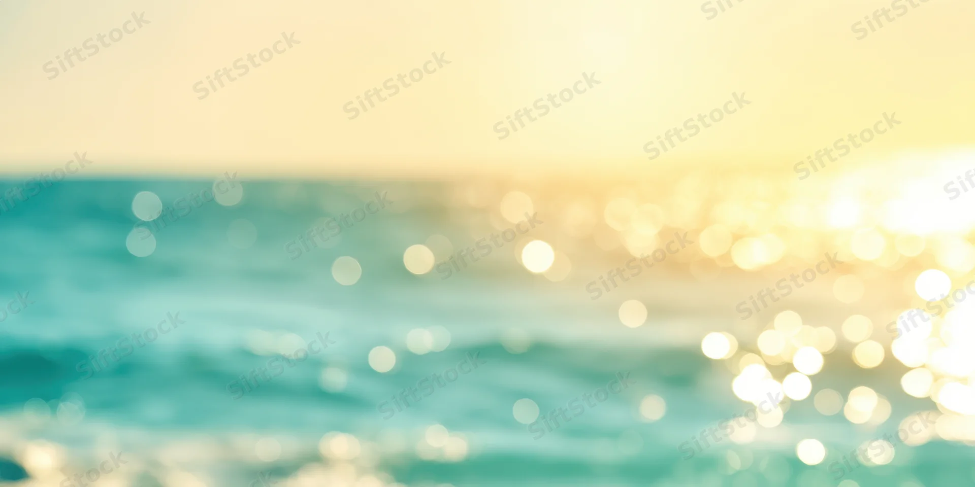 Golden sunrise over turquoise ocean with shimmering bokeh reflections on water surface