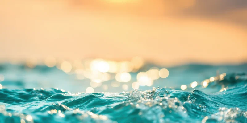 Turquoise ocean waves shimmering under golden sunrise light