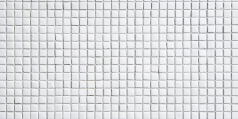 Seamless white square tile mosaic arranged in grid pattern on wall surface