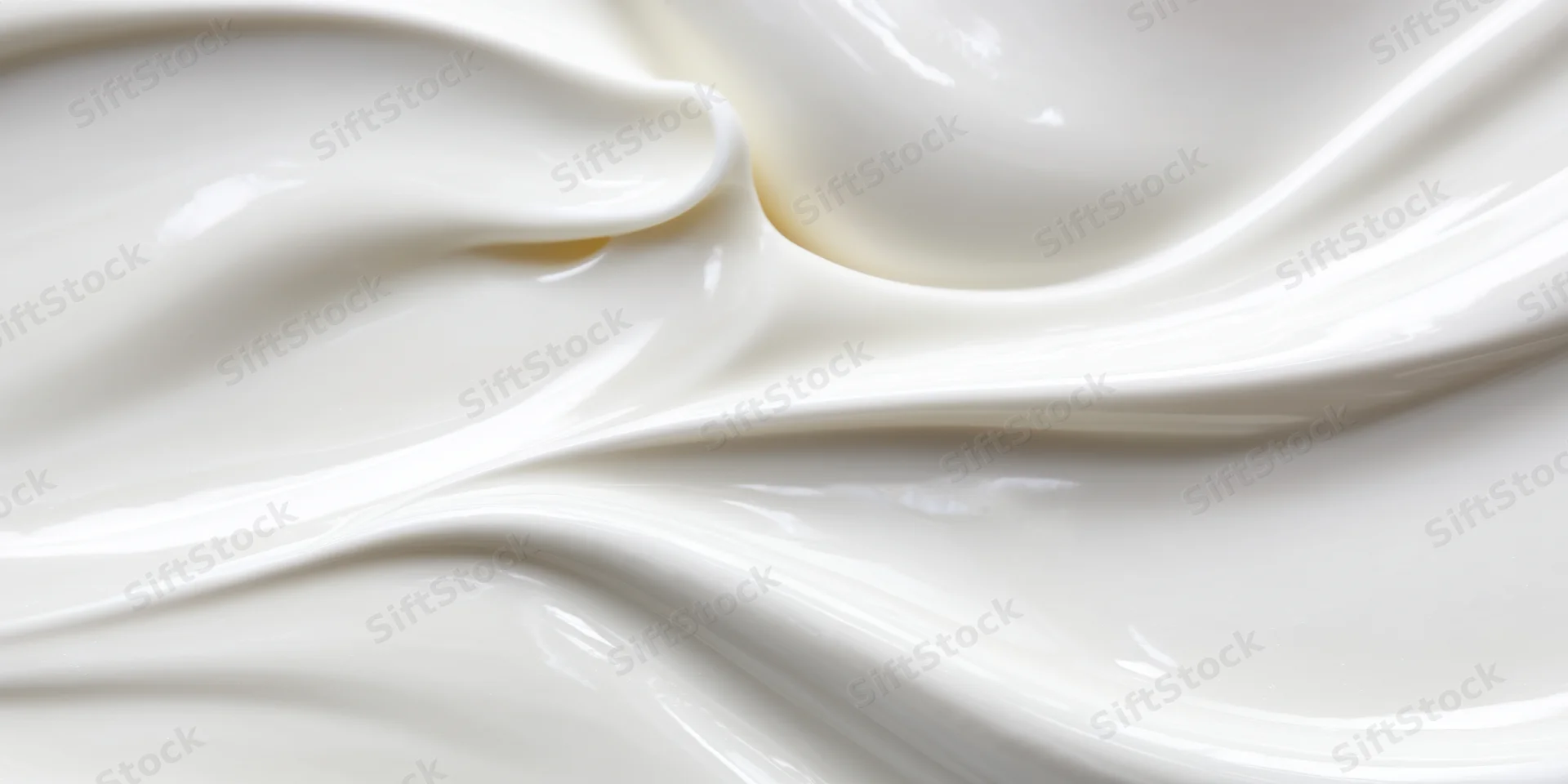 Close-up of silky white cream with smooth flowing swirls and glossy texture