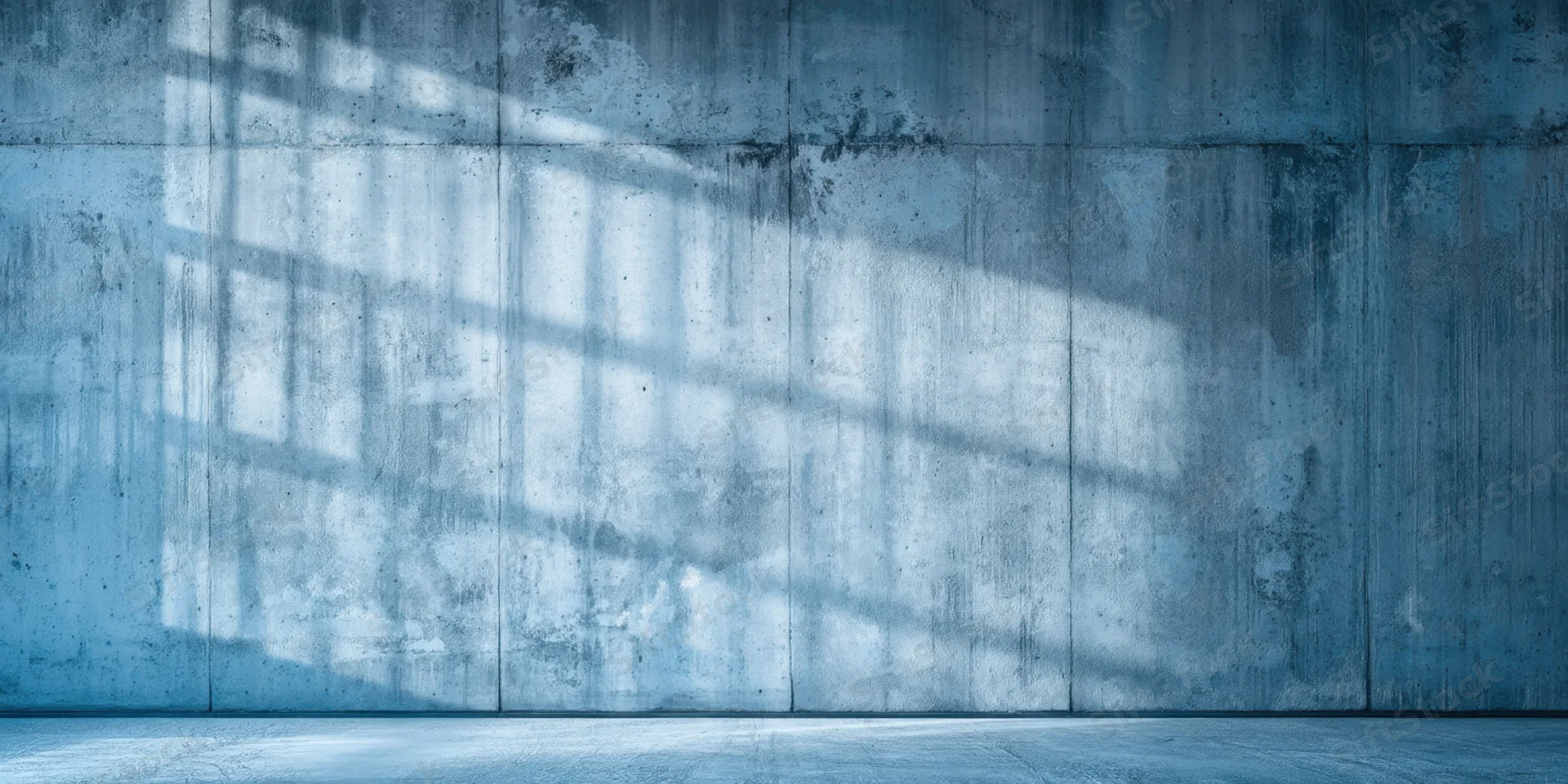 Weathered concrete wall with shadow pattern and empty floor in industrial interior
