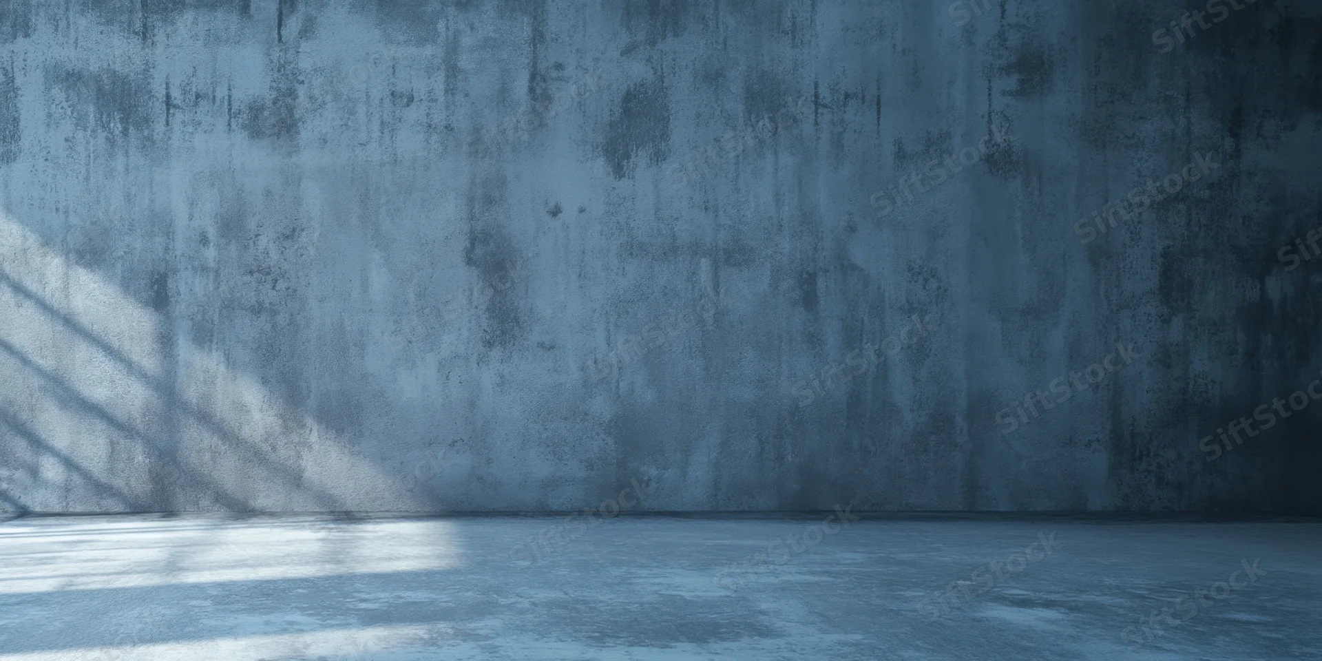 Weathered concrete wall and empty floor in cool blue light with window shadow
