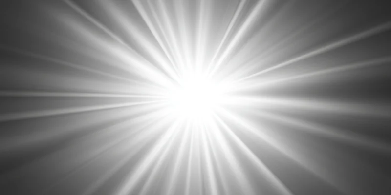 Bright light flare with radiating rays centered on a gray gradient background