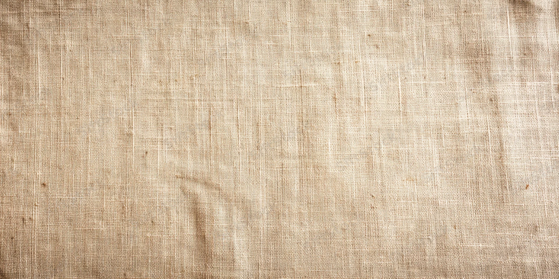 Close-up of beige linen fabric with fine woven texture filling the frame