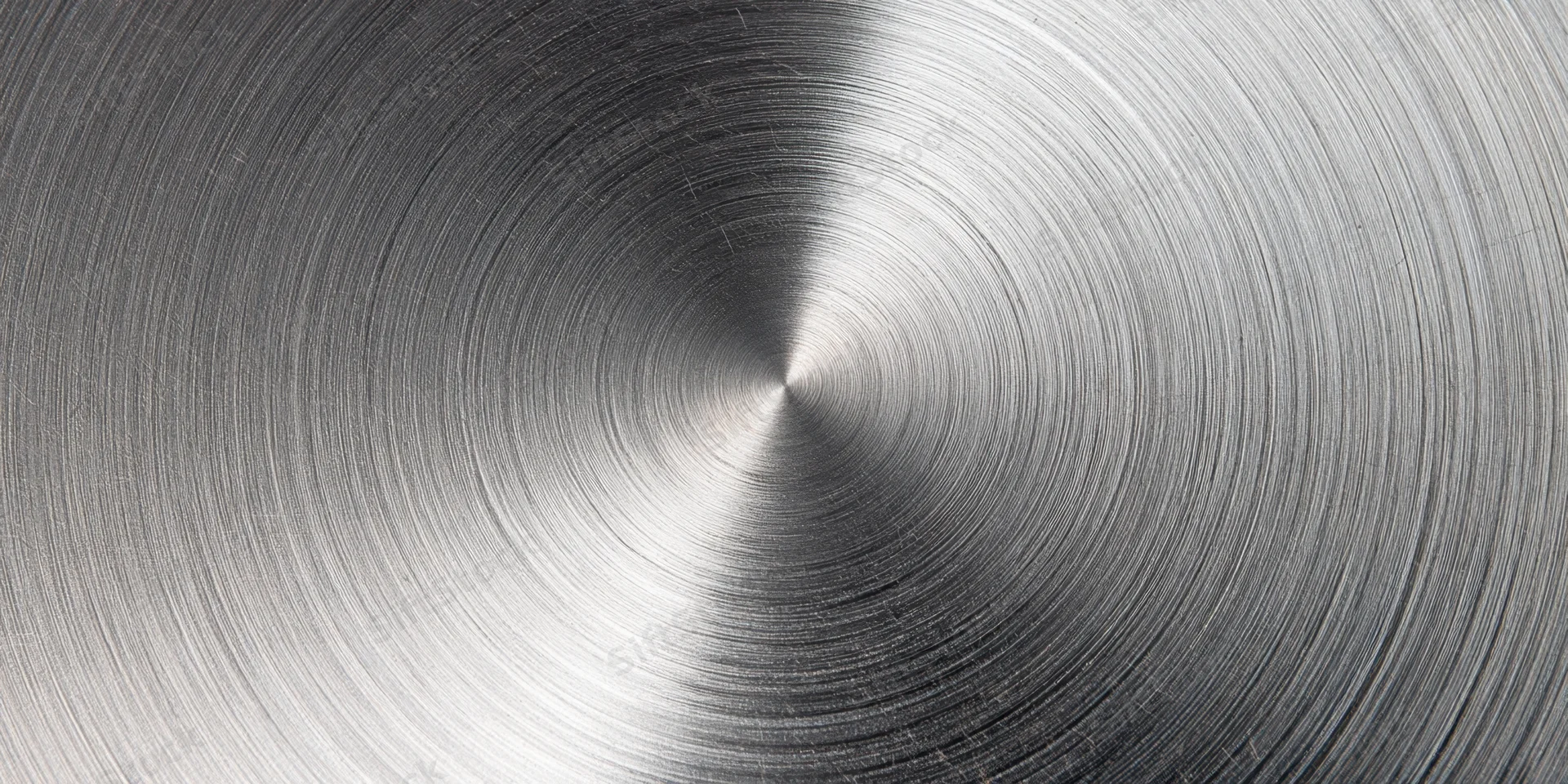 Close-up of a brushed metal surface with circular radial grain pattern