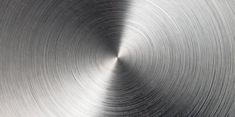 Close-up of a brushed metal surface with circular radial grain pattern