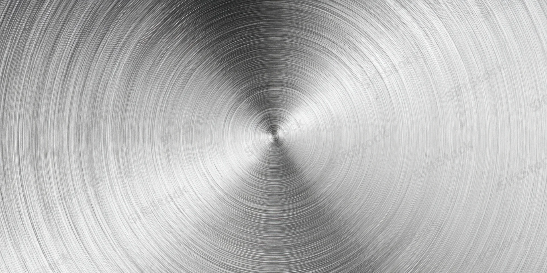 Close-up of a brushed metal surface with circular radial texture